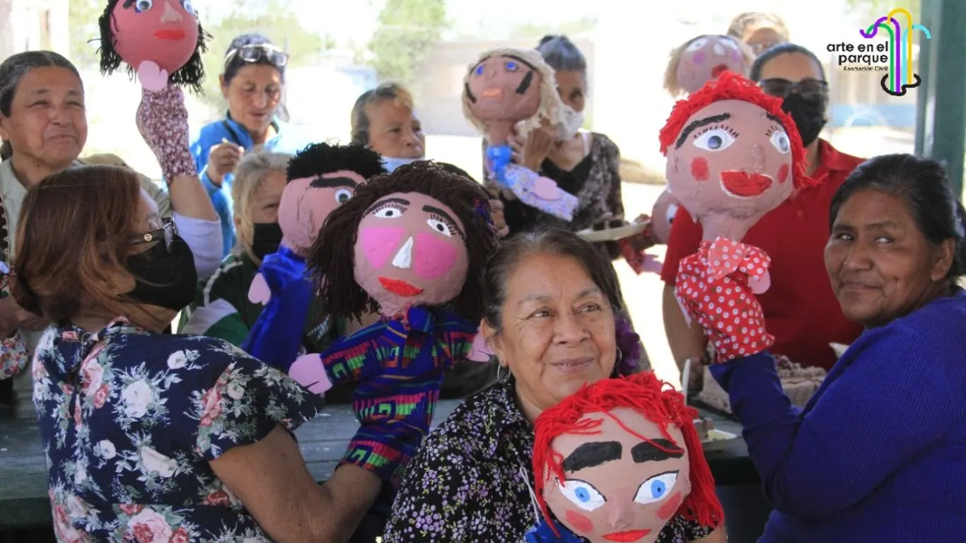 Mujeres sostienen títeres de colores en un taller